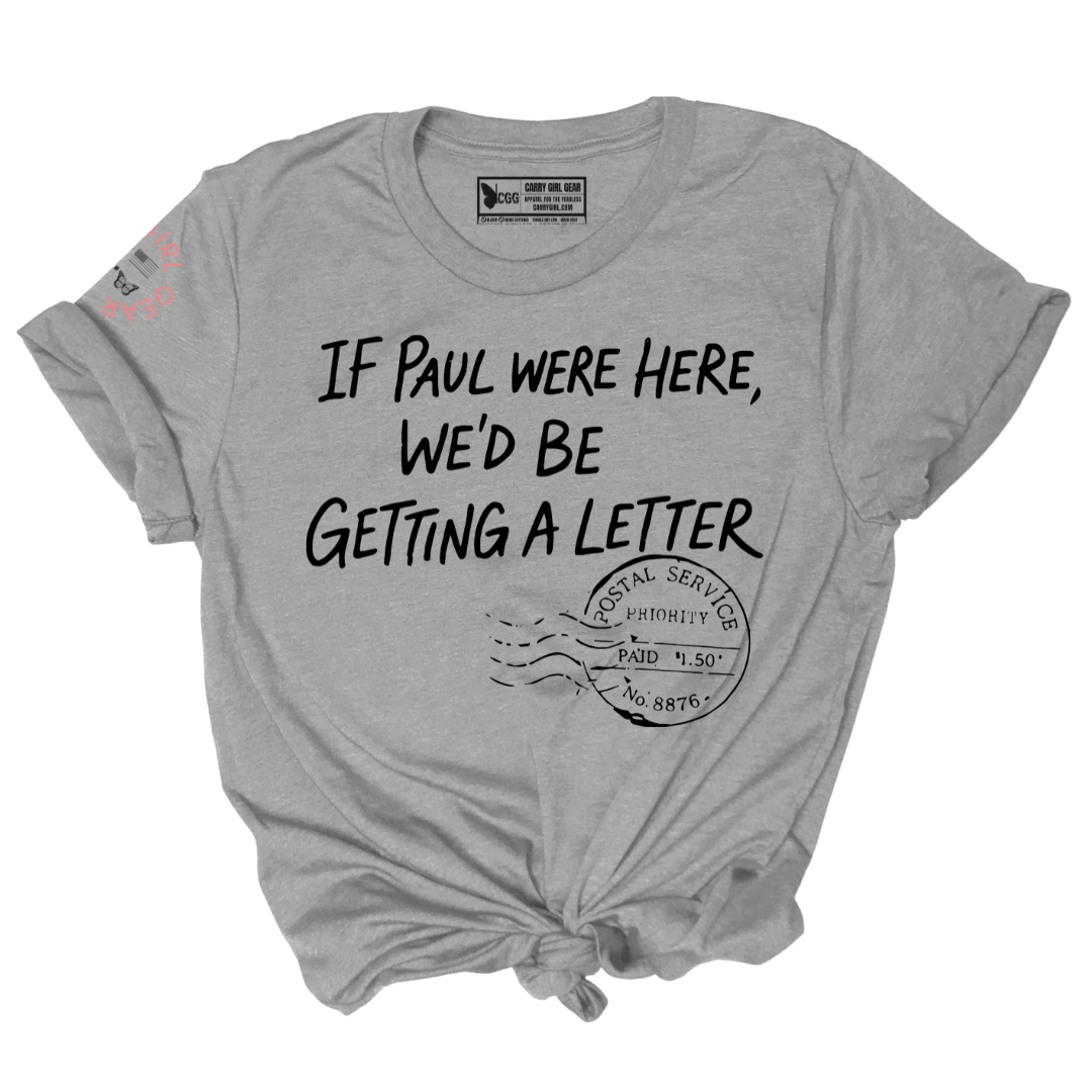A heather gray short-sleeve t-shirt with a distressed black graphic print that reads 'IF PAUL WERE HERE, WE'D BE GETTING A LETTER' above a postage stamp illustration. The t-shirt is styled with a knot at the bottom hem and a tie at the collar, shown on a plain white background.